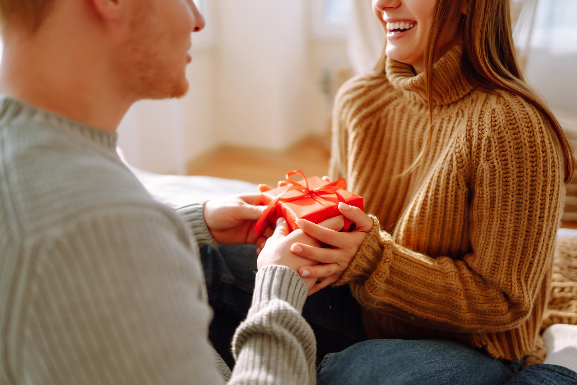 Valentine's Day concept. Exchange of gifts. Young couple at home celebrating Valentine's Day.